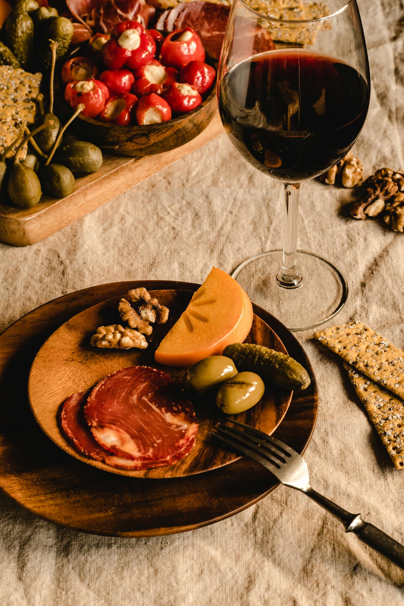 A stylish presentation of charcuterie, cheese, walnuts, and wine, perfect for gourmet dining.
